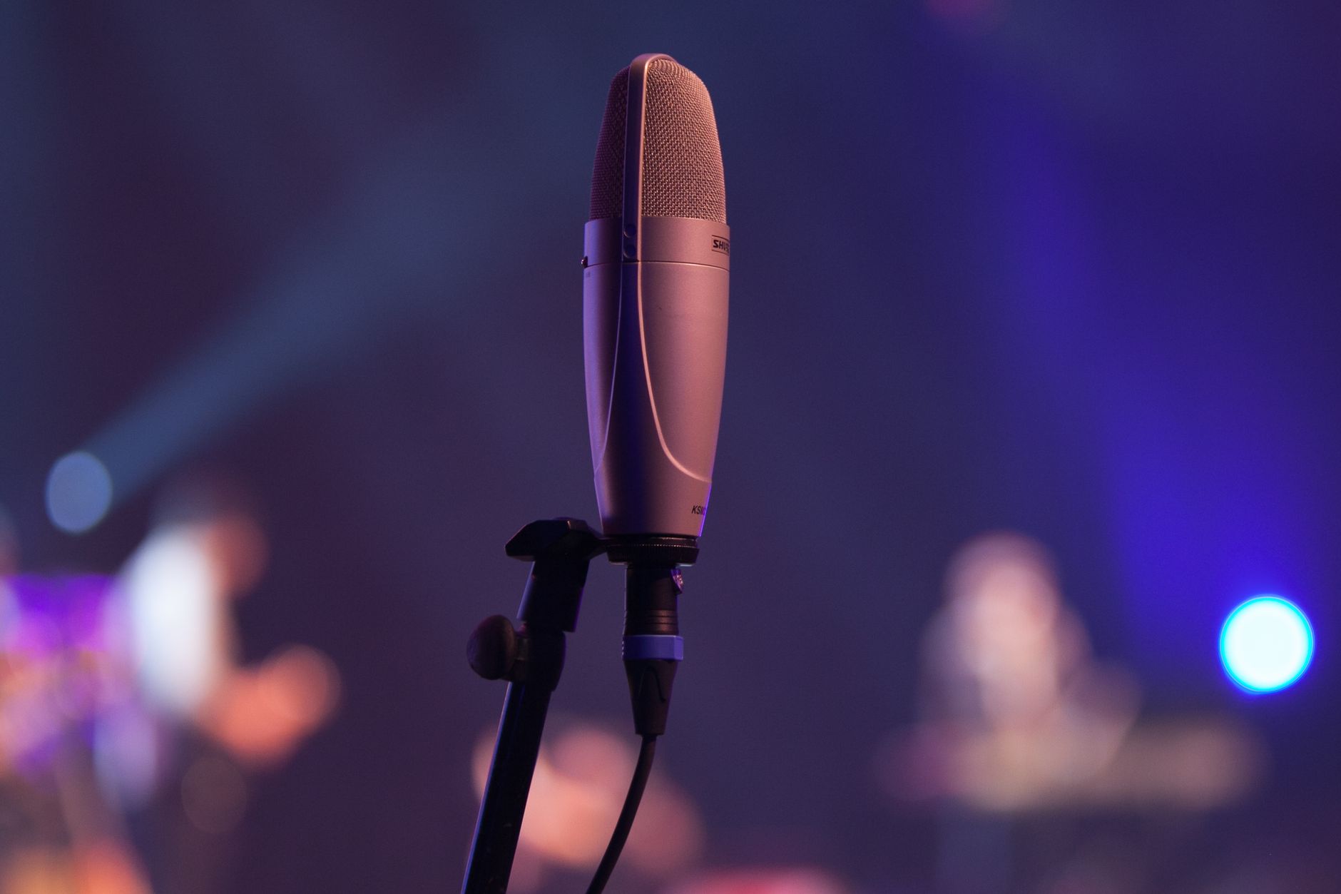 condenser microphone on stand close-up acoustic guitar background